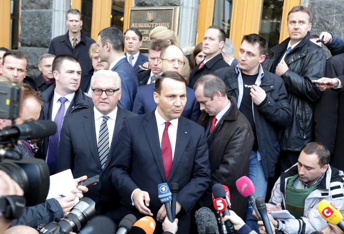 Ministrul de Externe al Poloniei,
Radoslaw Sikorski (centru), şi
omologul său german, Frank-Walter Steinmeier (stânga), se
adresează presei la Kiev, în februarie, după semnarea, cu medierea Uniunii
Europene, a acordului de pace dintre preşedintele Viktor Ianukovici şi liderii
opoziţiei.