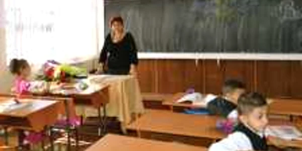 Învăţătoarea Gina Năstasă priveşte dezamăgită spre copiii răsfiraţi prin clasă