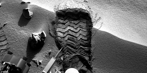 Urma lăsată de Curiosity pe Marte. Mai jos este cea lăsată de Neil Armstrong pe Lună