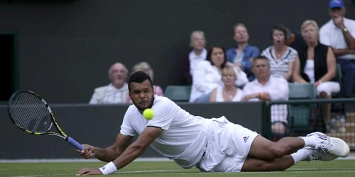 Francezul Jo-Wilfried Tsonga alunecă în timpul meciului contra austriacului Jurgen Melzer în partida de la Wimbledon Londra FOTO Reuters