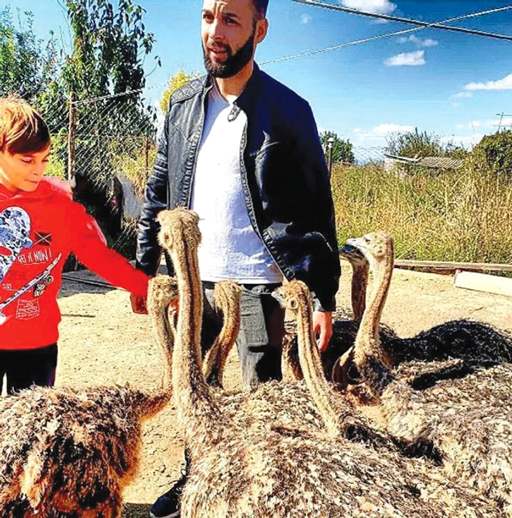 Răzvan şi  băieţelul familiei,  printre pui. Foto: adevarul.ro