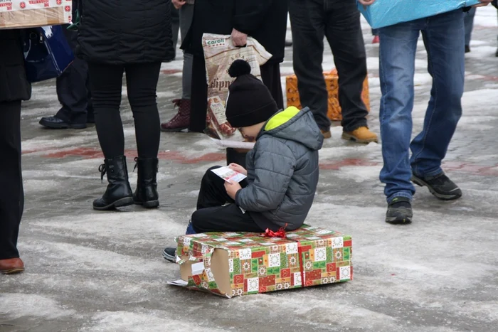 Cei mici s-au aşezat pe daruri şi au început să citească pliantul despre „Ziua Voluntarului Mic”, în cadrul căreia trebuie să dea înapoi comunităţii FOTO: Bianca Sara