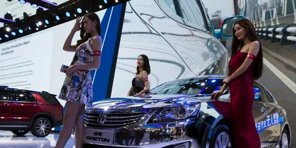 Modele pozează lângă o maşină fără şofer Changan expusă la Auto China 2016 de la Beijing China FOTO AP