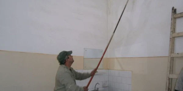Muncitorii curăţă mucegaiul de pe pereţi