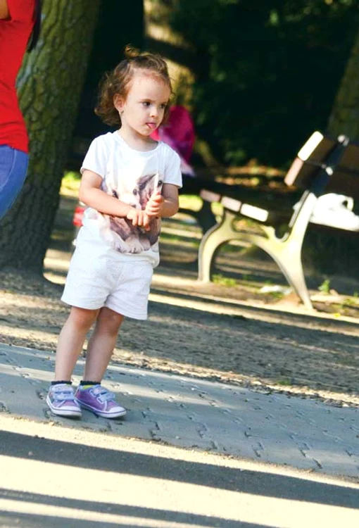 Micuța stă tristă în mijocul parcului...