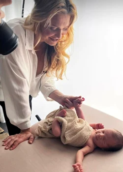 Înfășat și aranjat, băiețelul zâmbește la un moment dat în fața aparatului de fotografiat