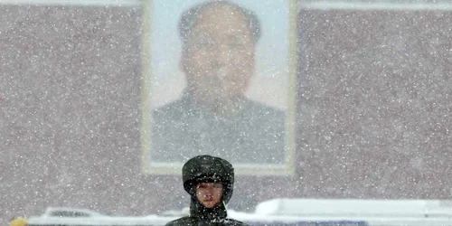 Un poliţist paramilitar stă de pază în timpul ninsorii puternice lângă portretul liderului chinez Mao Zedong la poarta Tiananmen din Beijing China FOTO AP
