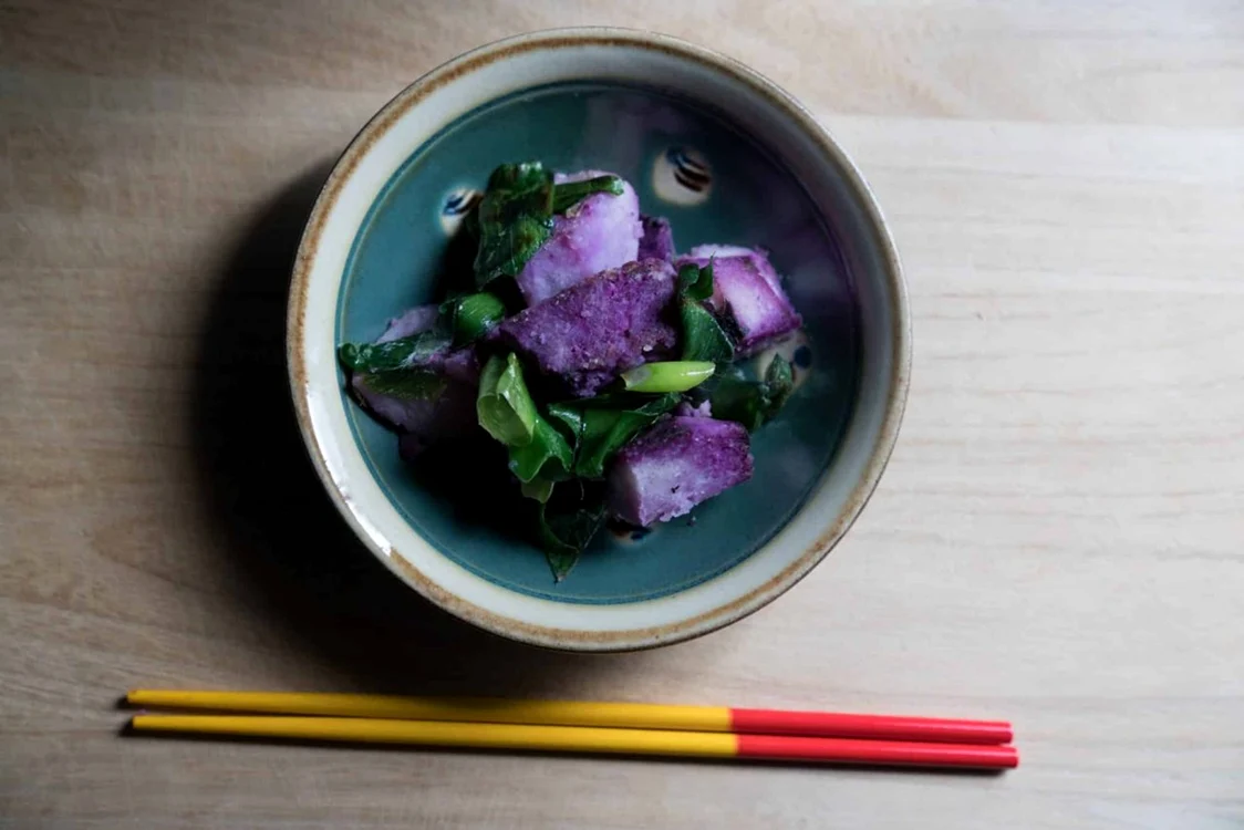 Un bol cu salată de cartof dulce violet, alături de hashi – bețișoarele pentru mâncat Bluezones.com
