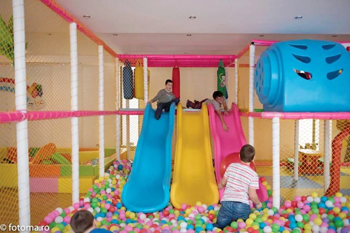 Copiii se joacă, în timp ce părinţii se află în sala de teatru