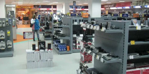 O băcăuancă analizează mărfurile expuse într-un magazin de electrocasnice