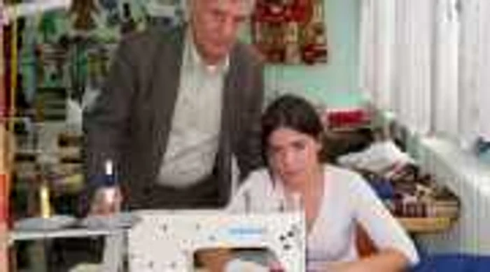 Dana Boerean, o elevă, în clasa a X-a, confecţionează un drapel cu ajutorul şefului de atelier, Petre Floare 