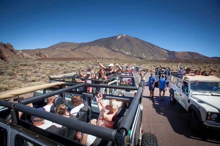 Jeepuri cu turiști pregătiți pentru un tur la Parcul Național Teide de pe Insula Tenerife.