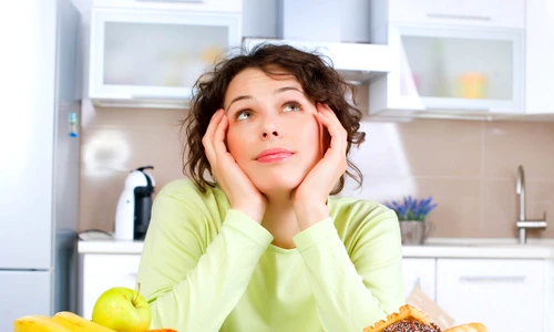 Beautiful Young Woman choosing between Fruits and Sweets jpeg
