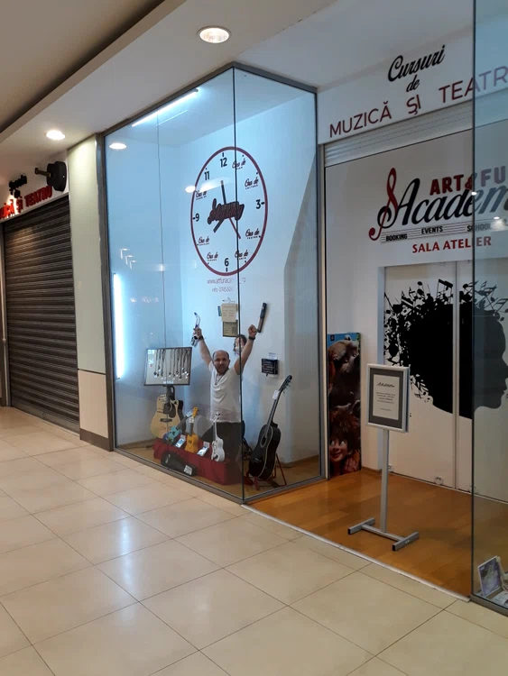 Marius Gheorghiu, în vitrină, în fața atelierului său