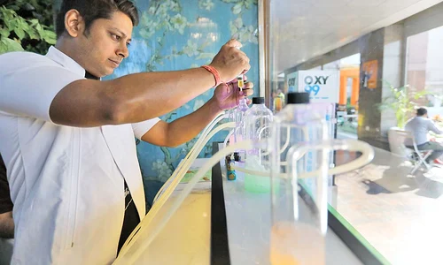 Un barman specializat în ”cocteiluri cu oxigen” prepară recipientele care vor fi livrate la domiciliul clientului jpeg