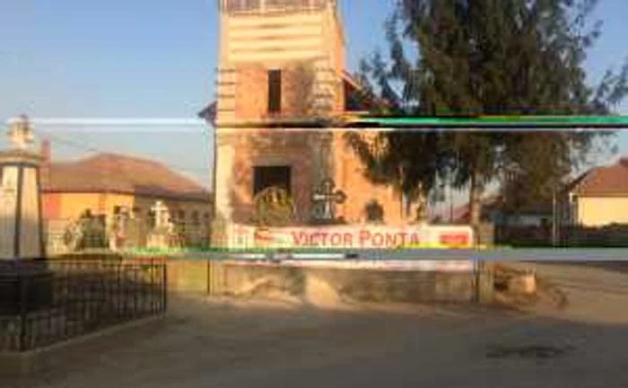 Bannerul electoral de pe gardul cimitirului