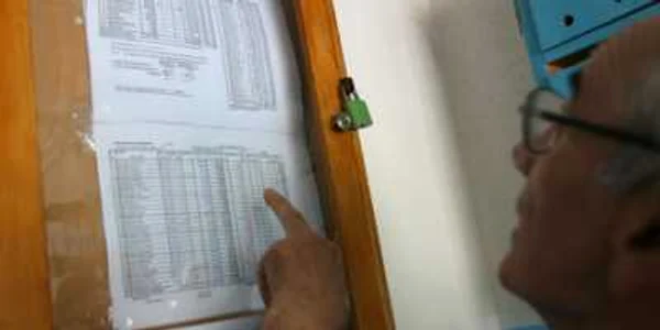 Un locatar îşi verifică ultima factură afişată la panoul de administraţie din scară