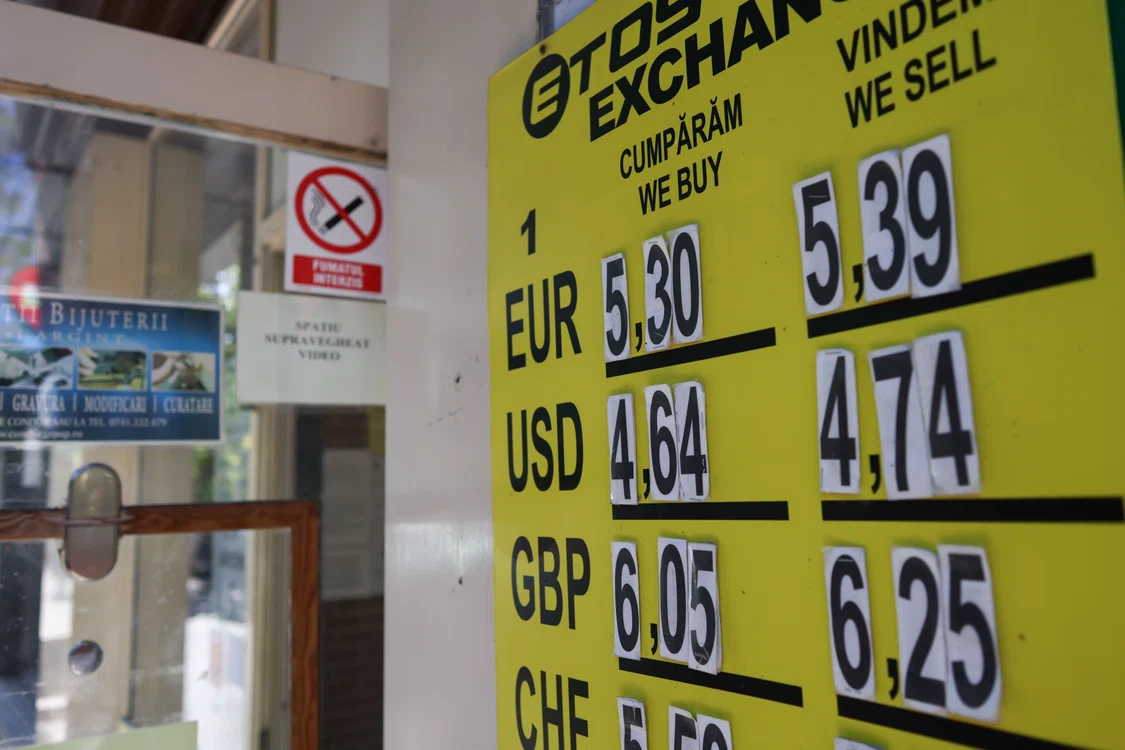 Panou galben cu ratele de cumpărare și vânzare pentru euro, dolar american și liră sterlină.