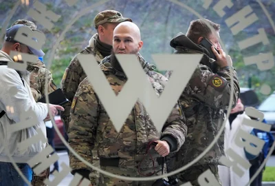 Vizitatori îmbrăcați în camuflaj militar stau la intrarea  Centrul Wagner din Rusia FOTO Profimedia 