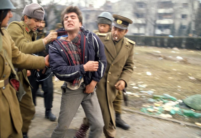 Tanăr ridicat de soldați în Timișoara în timpul Revoluției Române, decembrie 1989 GettyImages