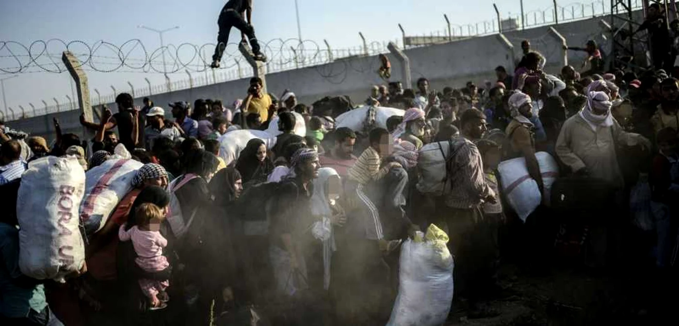 Refugiaţi sirieni trec gardul de frontieră ilegal pentru a ajunge în Turcia, în apropiere de vama Akçakale, regiunea Sanliurfa FOTO BULENT KILIC/AFP/Getty Images