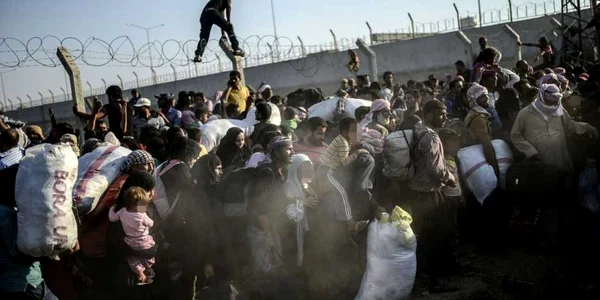 Refugiaţi sirieni trec gardul de frontieră ilegal pentru a ajunge în Turcia FOTO BULENT KILIC/AFP/Getty Images