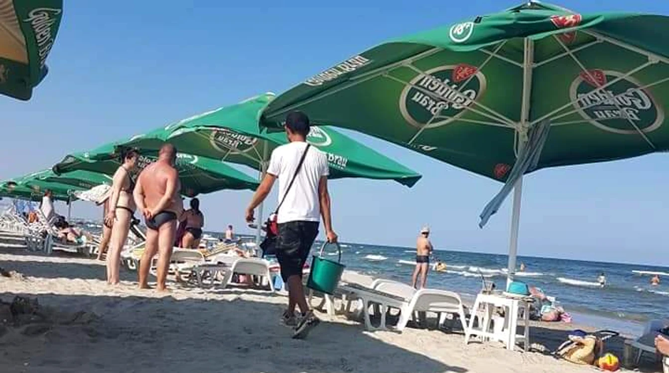 Tânărul din imagine vinde porumb la găleată
