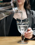 closeup woman pours water into glass cafe jpg