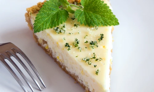 Piece of delicious homemade lemon cheesecake with mint close up jpeg