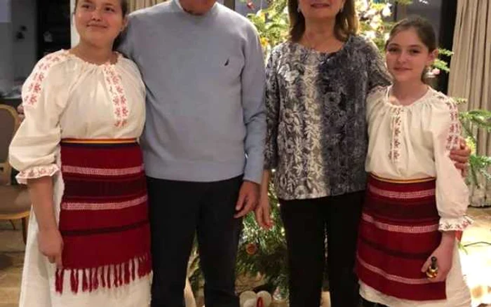 Traian Băsescu şi soţia sa, alături de doi copii dintr-un grup de colindători. FOTO Facebook Traian Băsescu