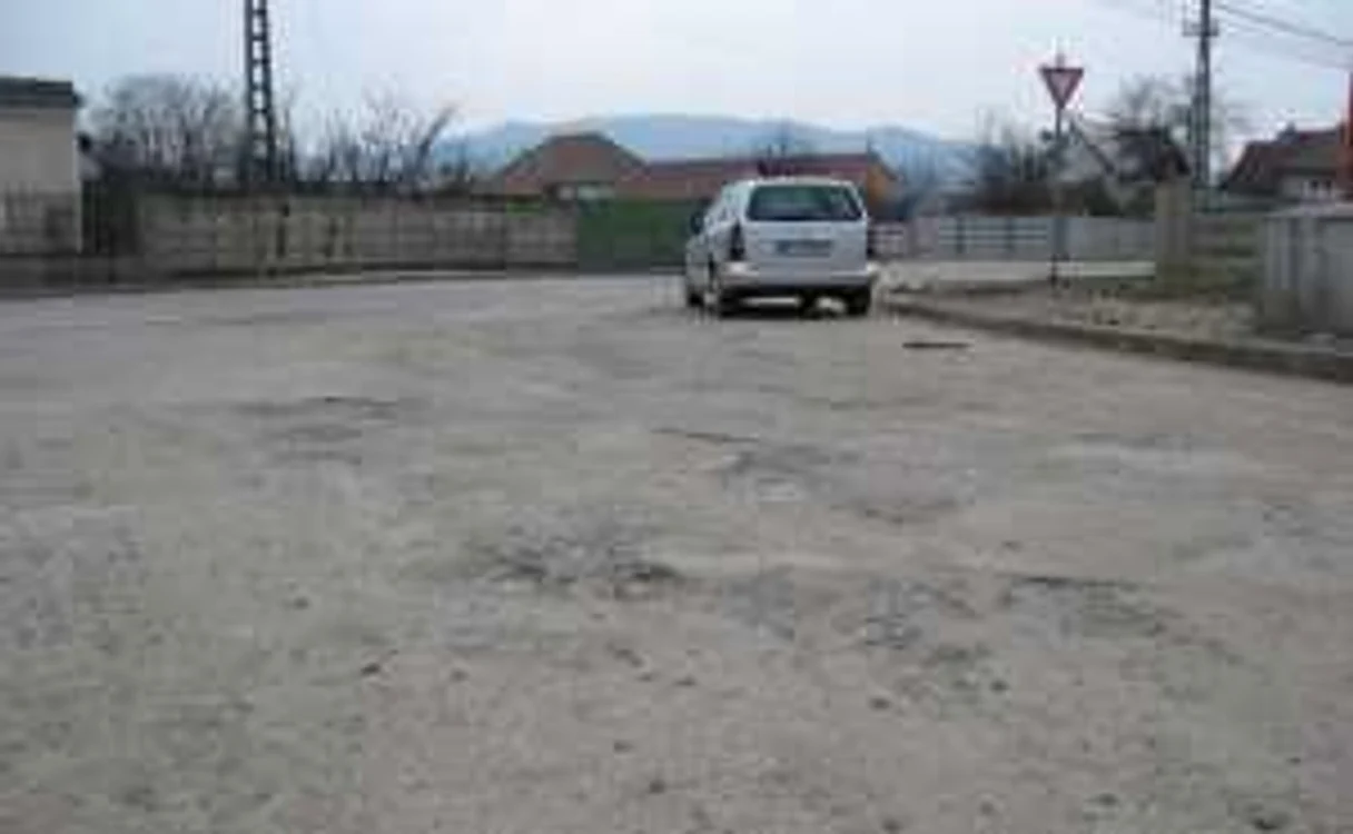 Maşinile fac slalom printre gropile din betonul de pe stradă