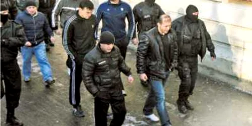 Eugen Preda (în blugi şi adidaşi albi) şi 13 presupuşi complici ai săi au fost arestaţi la 27 decembrie 2009  