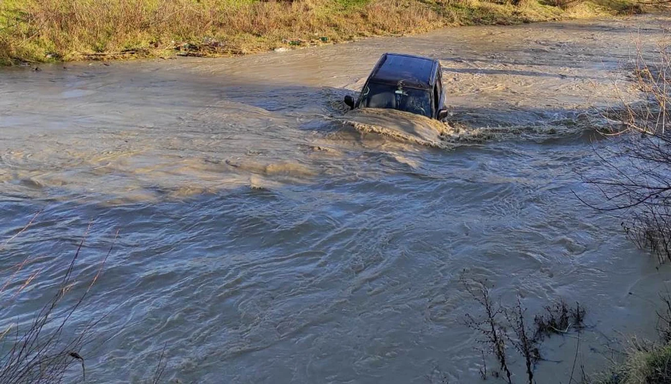 
    Mașina a rămas blocată în apele învolburate ale Râului PesceanaFoto: ISU Vâlcea  