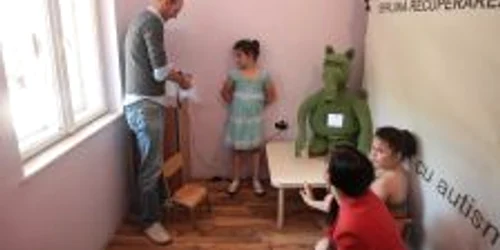 Jelle Saldien (stânga), alături de roboţelul pe care l-a conceput şi de copiii clujeni care se bucură de ajutorul lui terapeutic.