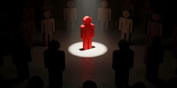 red figure standing out in spotlight surrounded by dark figures in a dim room symbolizing leadership individuality and standing out from the crowd photo jpg