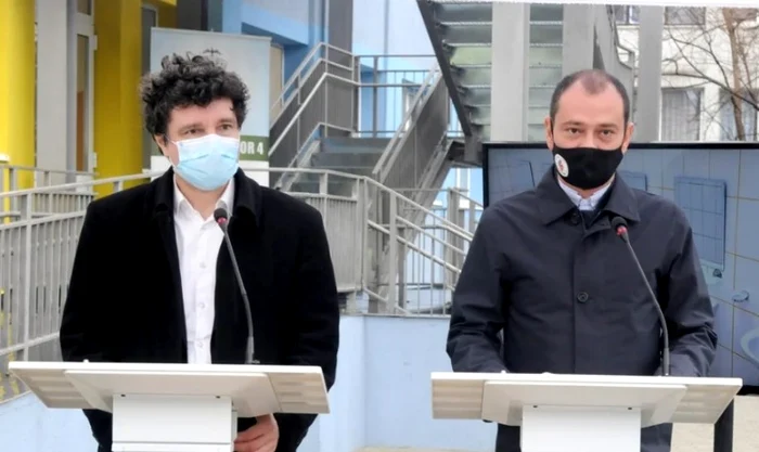 Nicușor Dan și Daniel Băluță la două pupitre diferite cu măști de protecție pe față