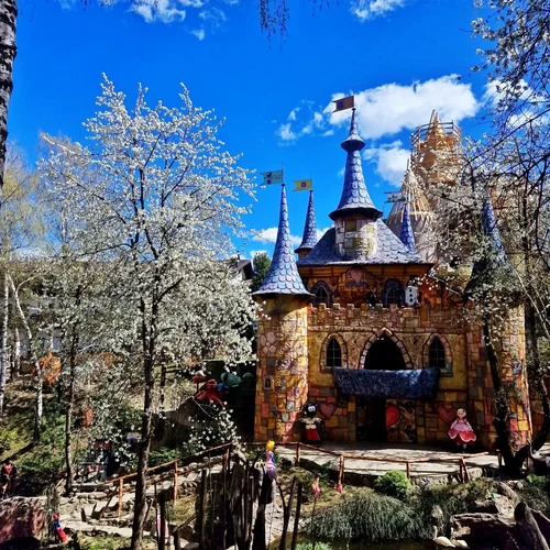 Castel tematic colorat cu turnuri albastre și personaje de basm într-un parc de distracție pentru copii din România.