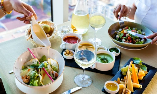 oameni care stau la masa salate supe branzeturi jpg