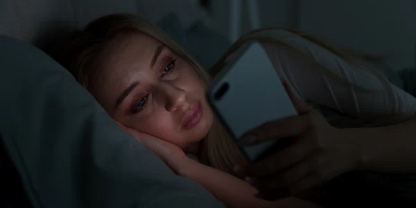 Femeie in pat cu telefonul in mana FOTO Shutterstock