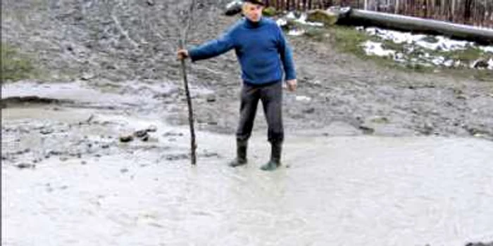Un sătean se pregăteşte să treacă prin apa pârâului Sărăţel