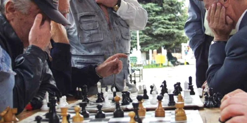 Pensionarii joacă table sau şah în parcuri