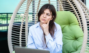 serious young woman works laptop while sitting hammock jpg