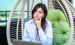 serious young woman works laptop while sitting hammock jpg