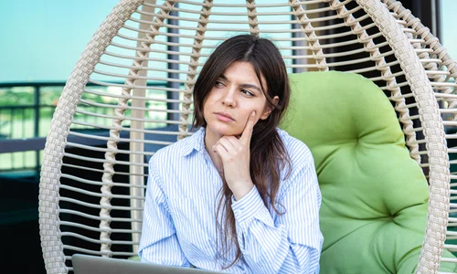 serious young woman works laptop while sitting hammock jpg