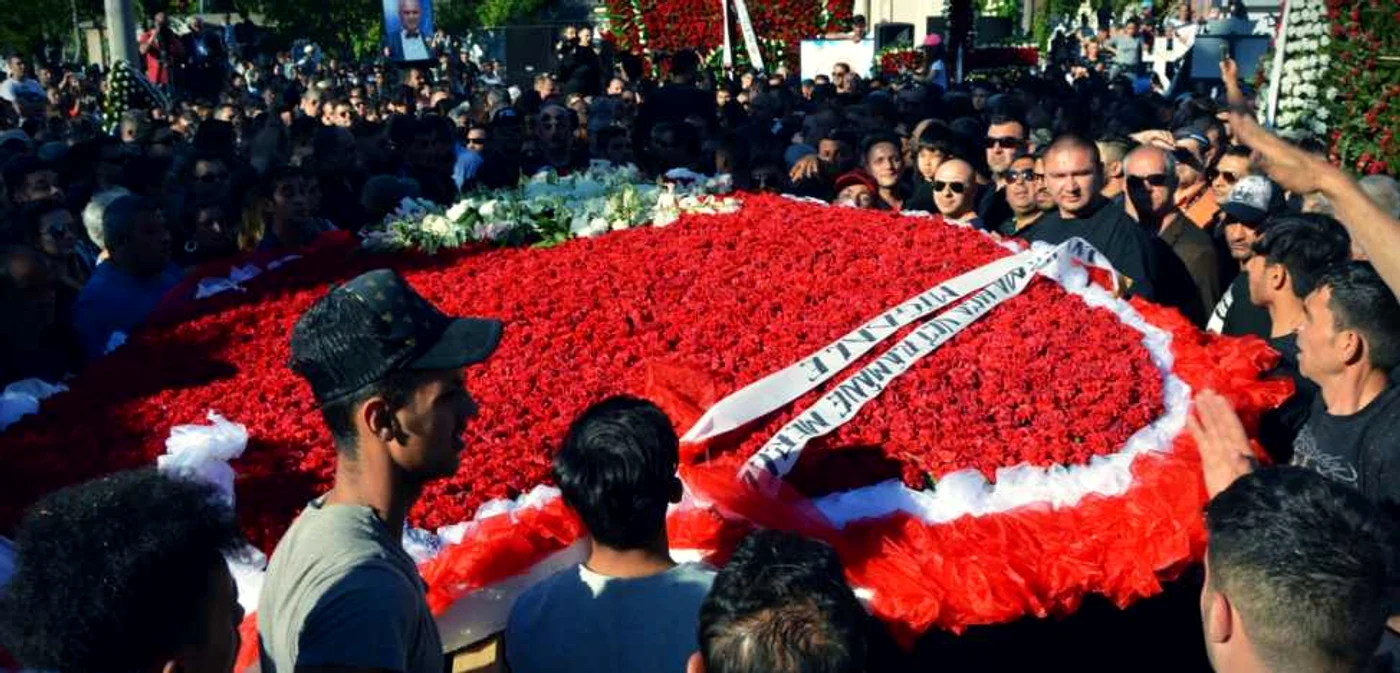 Coroane de flori de 3 şi 5 metri, cărate de zeci de bărbaţi spre mormântul lui Fane. FOTO: Cristian Delcea