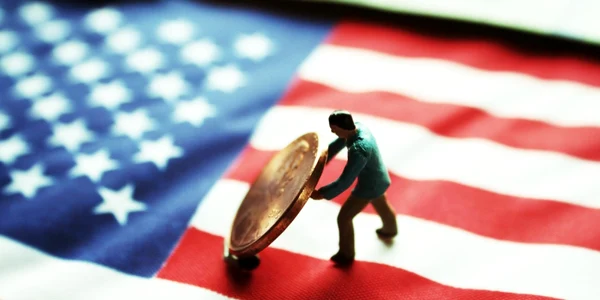 Un bărbat cară o monedă pe un steag american FOTO Shutterstock