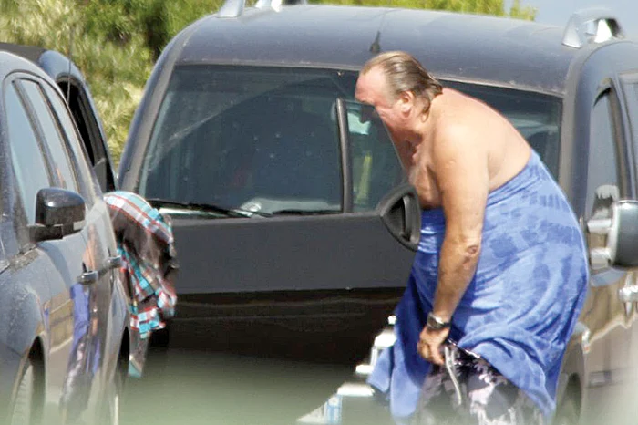 Actorul se lasă fără jenă  la pielea goală, apoi îşi  trage repede şortul de plajă