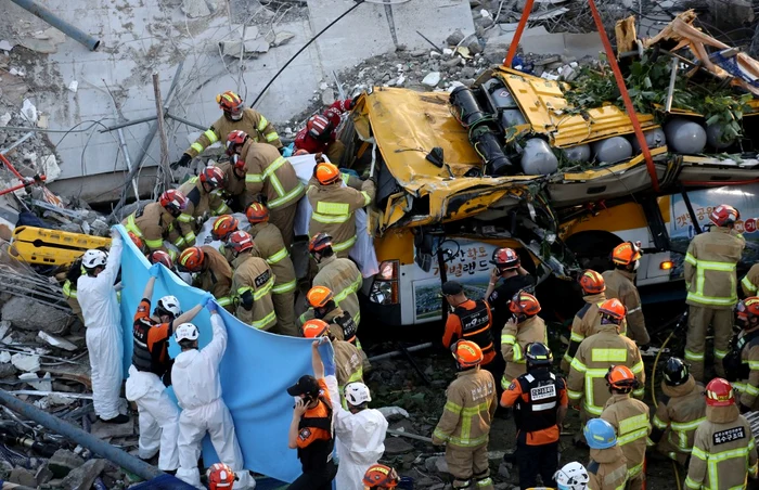Cel puțin nouă oameni au fost uciși în Coreea de Sud, după ce o clădire cu cinci etaje s-a prăbușit pe autobuzul în care se aflau în timpul demolăriiFoto: AFP