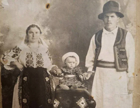 O familie tradițională din 1932: mama, copilul și tatăl, îmbrăcați în port popular