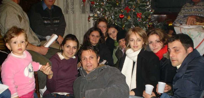 Colindătorii beau un ceai cald, lângă brad.